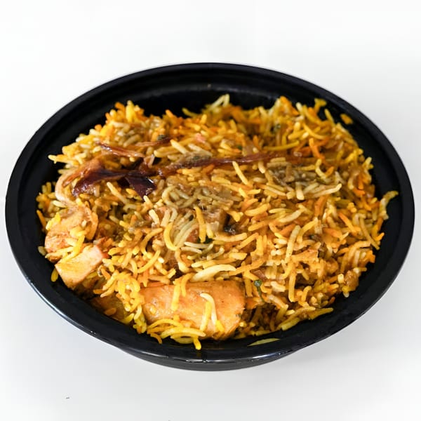 A black bowl filled with Gol Bowl's chicken biryani, featuring long-grain rice and chicken pieces.