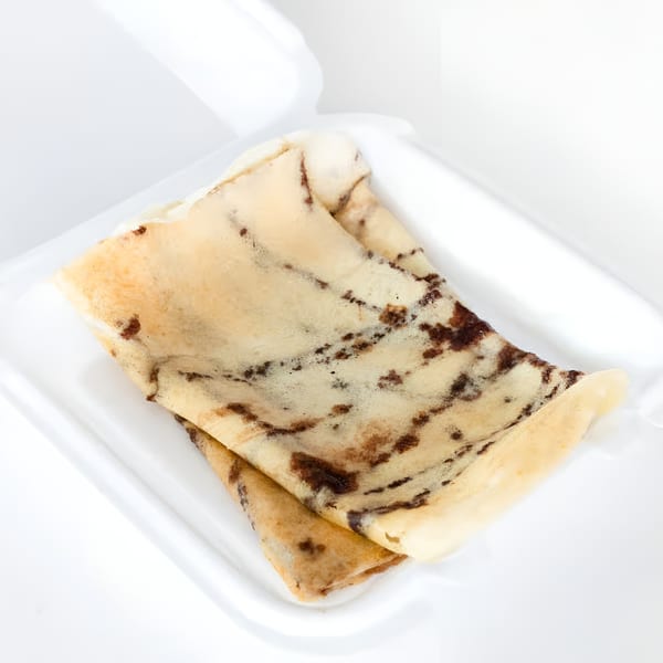 Two folded, light brown crepes with dark brown speckles, served in a white container.